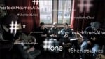 Photo: BBC via Google. Three people are sitting on the sofa. They are all big fans of Sherlock Holmes. On the screen there is hash-tags of Sherlock Is Not Dead.