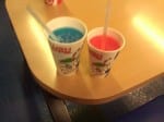 A photo of a red Slush Puppie and a blue one.