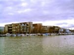 A view of Lincoln's Brayford Pool with the University of Lincoln in the background. The sky is grey and cloudy.