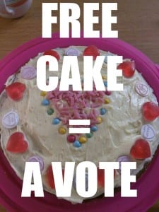 Picture  of a cake with text saying free cake = a vote